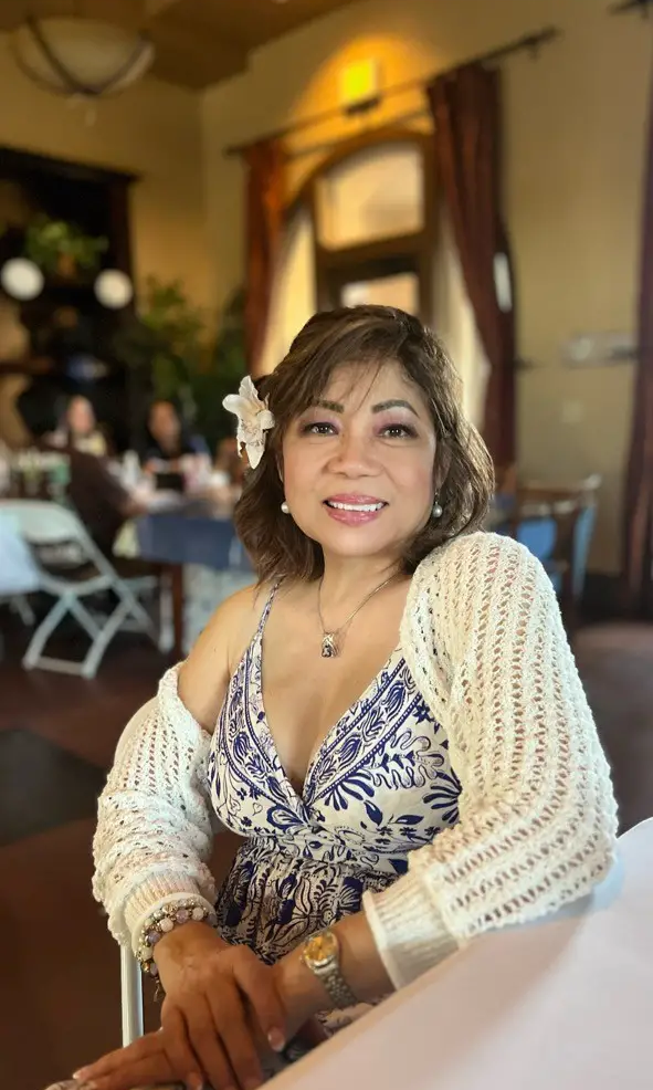 Portrait of Dr. Rossana T. Alfonso smiling while seated in a warm indoor setting, representing a friendly and experienced dentist in National City CA - Dentist National City CA